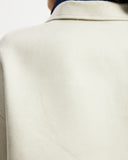 Model wears workwear jacket in a cream bone suede