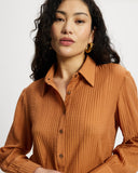Woman wearing a long sleeve orange ribbed shirt