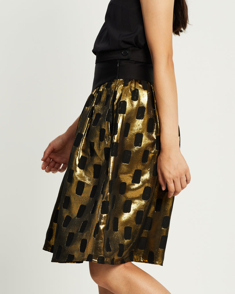 Model wears Gold and Black patterned 80s skirt