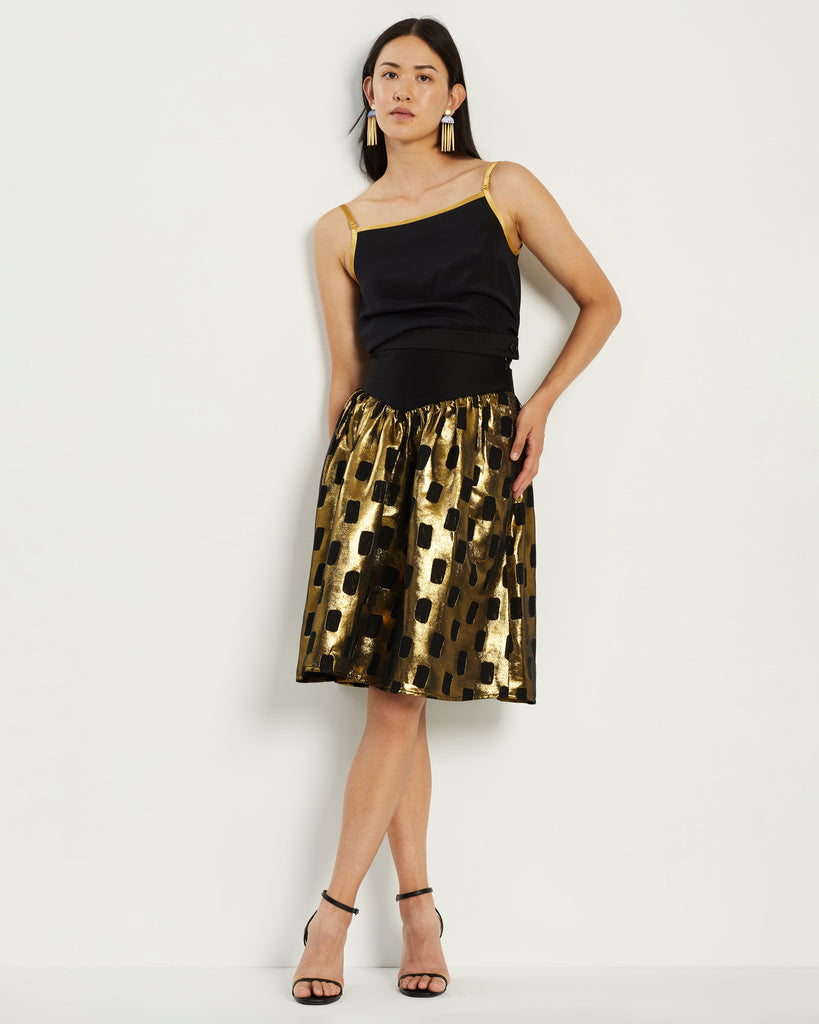 Model wears Gold and Black patterned 80s skirt