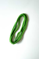 green apple silk long strand necklace by tabitha foundation against white backdrop