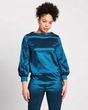 woman wearing bishop sleeve top with voluminous sleeves, wide boat neck and cuff with matching straight leg pants