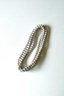 silver star silk long strand necklace by tabitha cambodia against a white backdrop