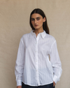 Woman wearing a white shirt against a beige background