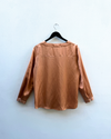 Nectar shirt on a hanger against a light blue wall