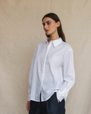 Model wearing a crisp white long-sleeve shirt.