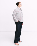 Person wearing a grey checkered shirt on a white background