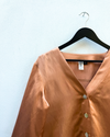 Nectar shirt on a hanger against a light blue wall