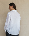 Model wearing a crisp white long-sleeve shirt.