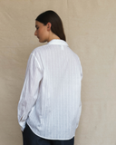 Model wearing a crisp white long-sleeve shirt.