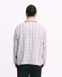 Person wearing a grey checkered shirt on a white background
