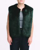 Green fur vest worn by a person on a white background