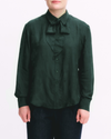Person wearing a dark green blouse with a bow tie on a white background