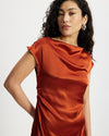 Woman wearing a rust-coloured satin midi dress 