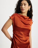 Woman wearing a rust-coloured satin midi dress 