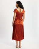 Woman wearing a rust-coloured satin midi dress 