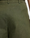Close-up of Khaki Denim cropped Bermuda shorts worn by a person on a white background