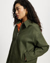 Woman wearing a  Khaki Denim Workwear Jacket with an orange shirt underneath on a white background