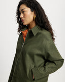 Woman wearing a  Khaki Denim Workwear Jacket with an orange shirt underneath on a white background
