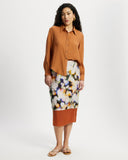 Woman wearing a long sleeve orange ribbed shirt 