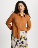 Woman wearing a long sleeve orange ribbed shirt 