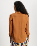 Woman wearing a long sleeve orange ribbed shirt
