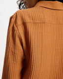 Woman wearing a long sleeve orange ribbed shirt 