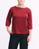 Red top worn by a person on a white background
