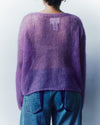 Person wearing a purple sweater and blue jeans against a plain background