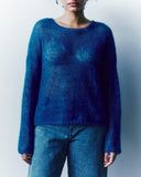 Person wearing a blue sweater against a white background