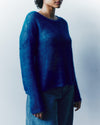 Person wearing a blue sweater against a white background
