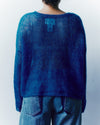 Person wearing a blue sweater against a white background