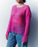 Person wearing a pink sweater and blue jeans against a white background