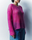 Person wearing a pink sweater and blue jeans against a white background