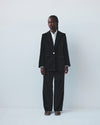 Person wearing a brown velvet suit with a white shirt on a white background