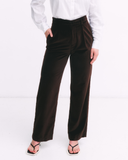 Brown pants worn by a person on a white background