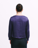 Person wearing a purple long-sleeve shirt on a white background