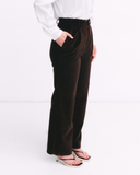 Brown pants worn by a person on a white background