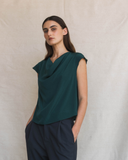 Model wearing Cowl top in transformative teal and dark pants against a neutral background.