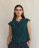 Model wearing Cowl top in transformative teal and dark pants against a neutral background.