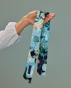 hand holding green and blue floral twilly scarf