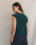 Model wearing Cowl top in transformative teal and dark pants against a neutral background.