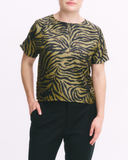 Person wearing a black and gold zebra print top with black pants on a white background