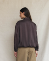 Model wearing a dark brown silk aviator bomber jacket.