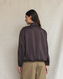 Model wearing a dark brown silk aviator bomber jacket.