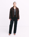 Brown jacket worn by a person on a white background