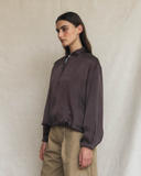 Model wearing a dark brown silk aviator bomber jacket.