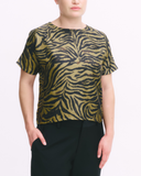 Person wearing a black and gold zebra print top with black pants on a white background