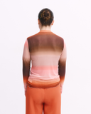 Person wearing a gradient shirt and orange pants on a white background