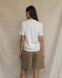 Model posing with her back facing the camera wearing an off-white t.shirt